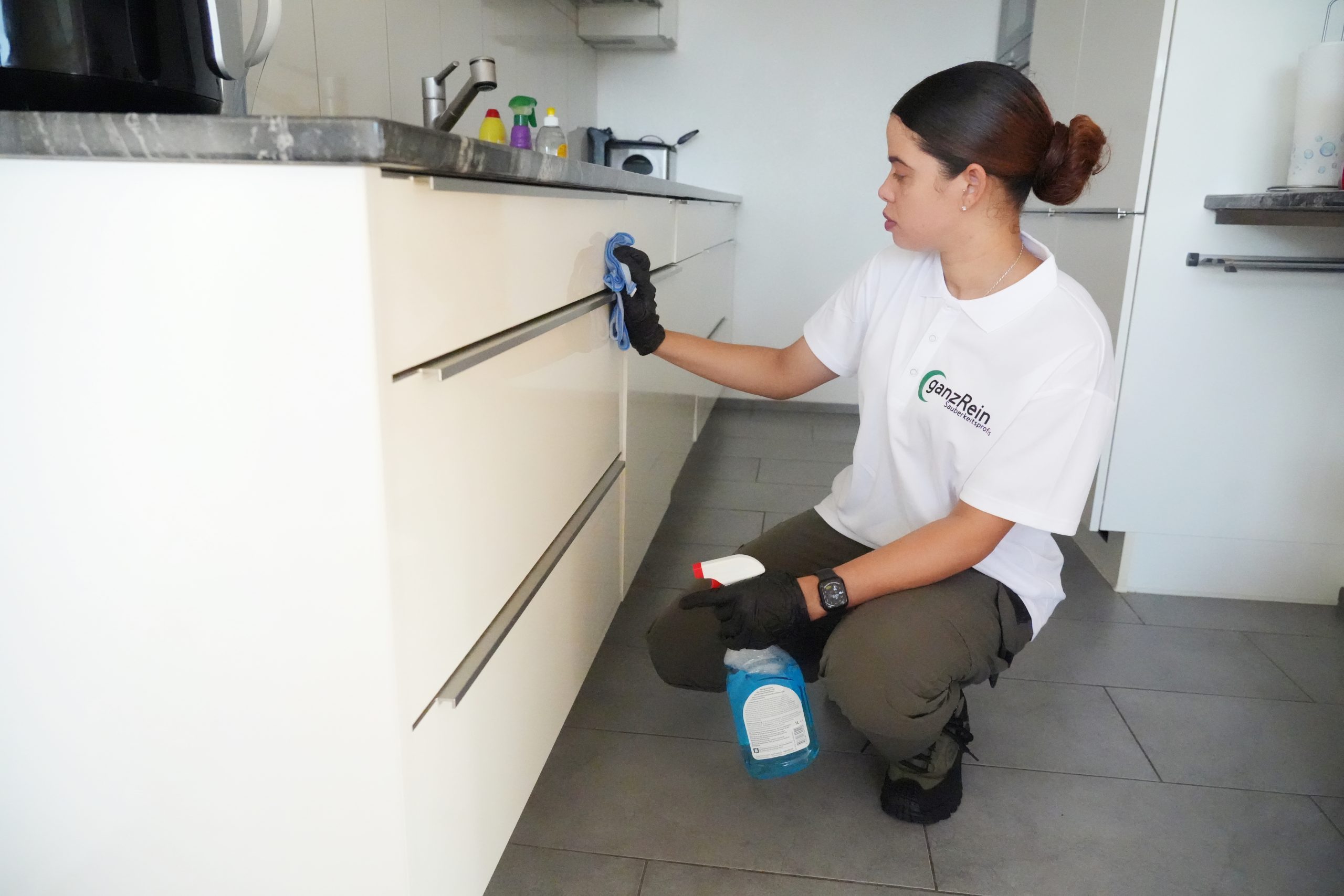 Reinigungskraft reinigt gründlich die Dunstabzugshaube in einer Küche in Bern